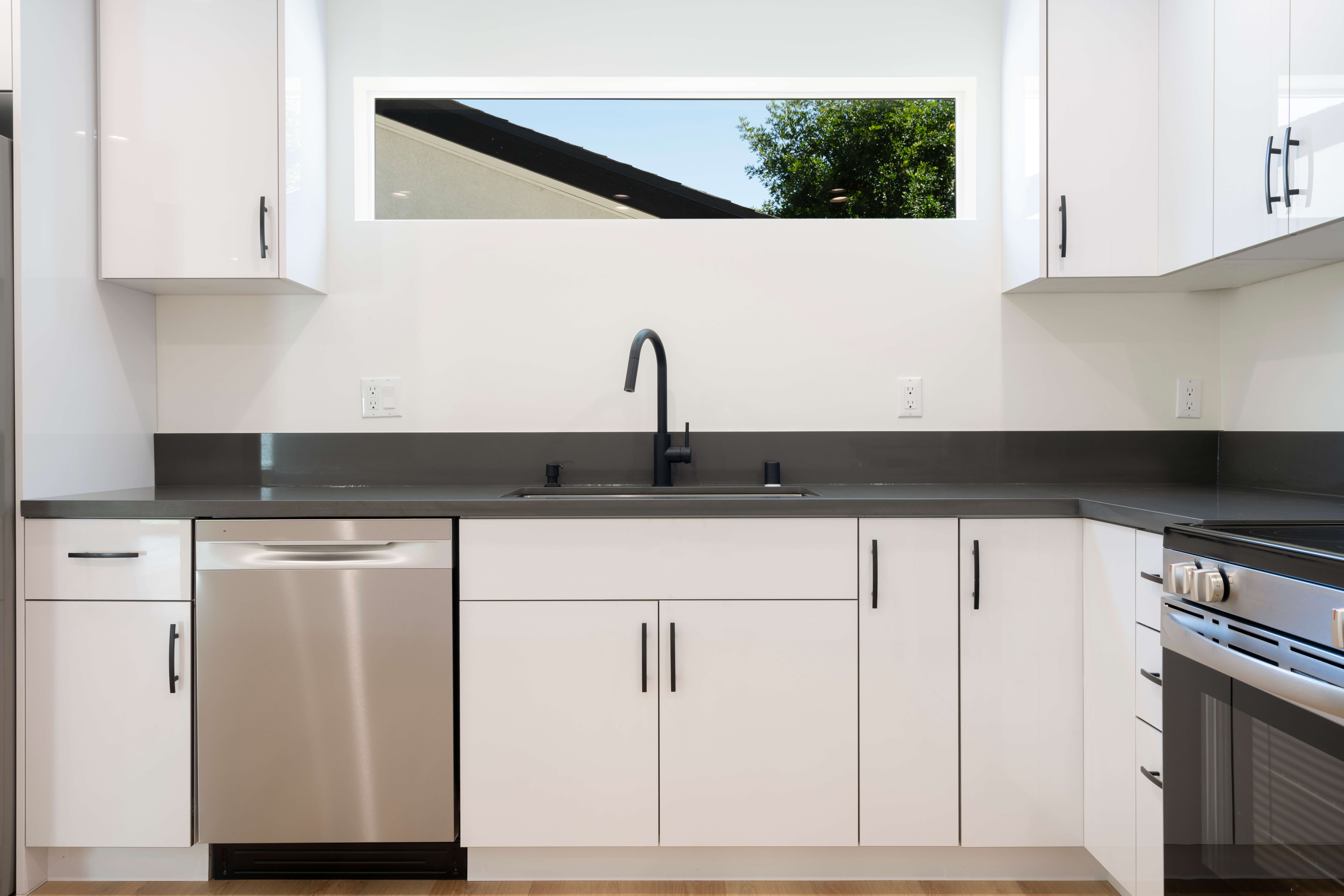 Modern ADU kitchen with white cabinets and professional appliances